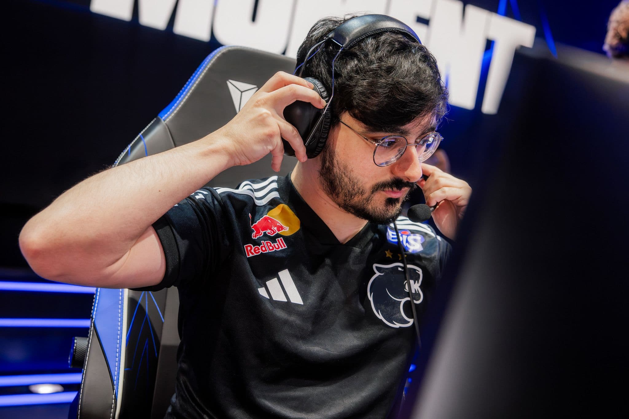 FURIA top laner Guigo adjusts his headset at his player station during Worlds 2026