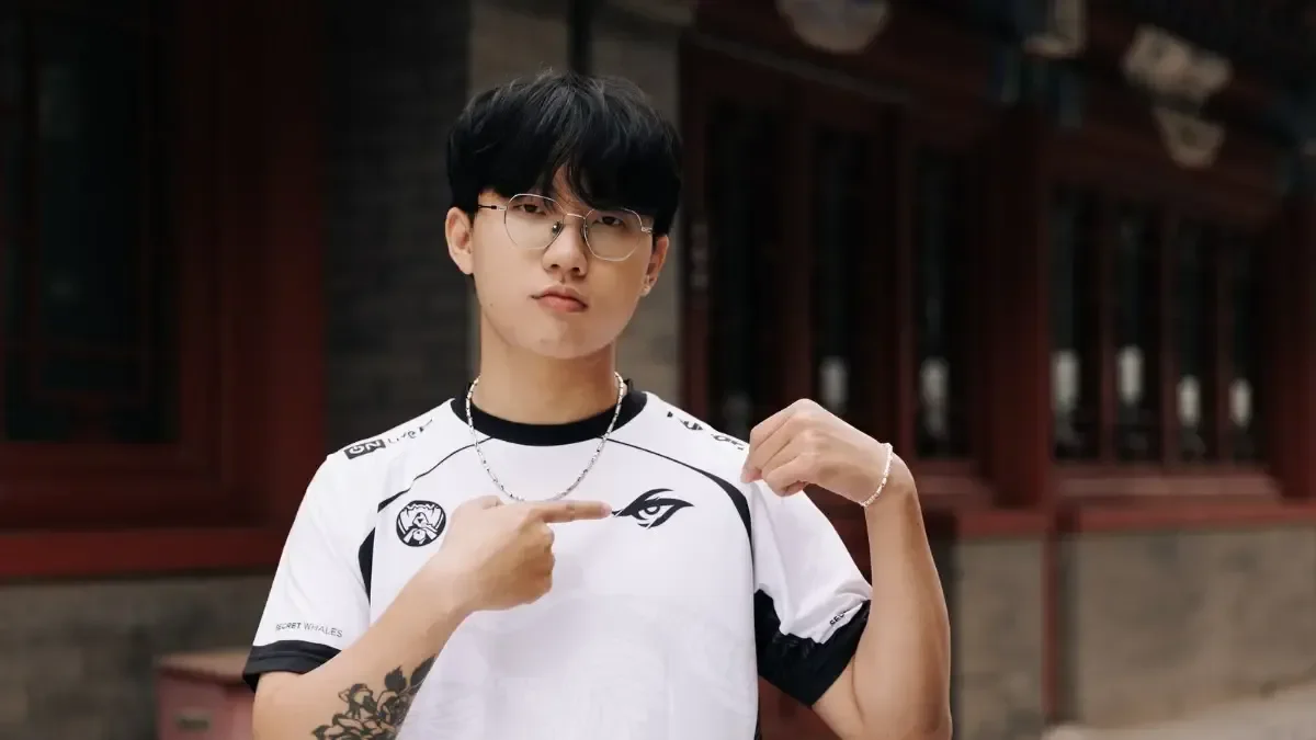 Faker pointing to the T1 team logo on his jersey, representing his status as the greatest League of Legends player of all time